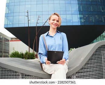 Smiling Eastern European Business Woman Looking At Camera With A Tablet In A Financial District. Businesswoman