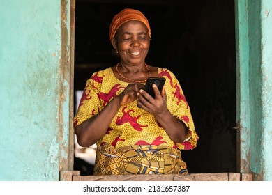 smiling elderly african woman using her phone - Shutterstock ID 2131657387