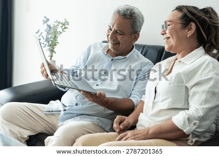 Smiling elderly couple embracing technology for communication and togetherness