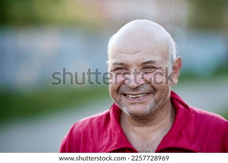 Smiling elderly European man 61 years old with bald head.