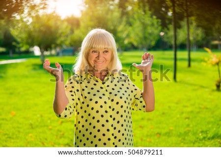 Smiling elderly female. Woman with raised arms outdoor. Life changes in an eyeblink. What a pleasant surprise.