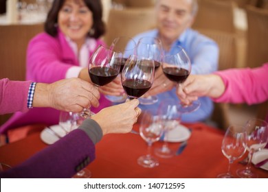 Smiling Elderly Friends Saying Cheers With Red Wine