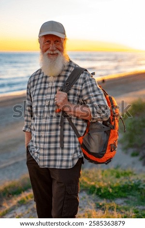 Smiling Elderly Man with Long White Beard and Backpack Enjoying 