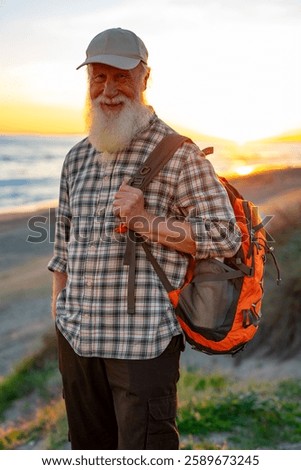 Smiling Elderly Man with Long White Beard and Backpack Enjoying 