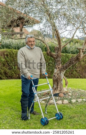 Smiling elderly man using a walking frame and wearing a leg brace, enjoying fresh air and sunshine in a peaceful garden, embodying rehabilitation and independent living