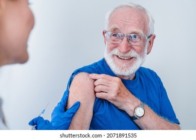 Smiling elderly old senior patient man grandfather in glasses is getting ready for injection vaccination against infectious disease coronavirus with smile isolated over white background - Powered by Shutterstock