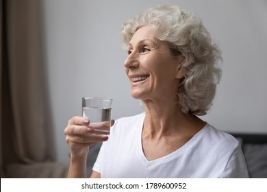 Smiling Elderly Woman Holding Glass Of Still Fresh Pure Distilled Water Enjoy Good Life Habit, After Awakening Morning Routine For Skin Body Health Care And Longevity, Healthy Lifestyle, Diet Concept