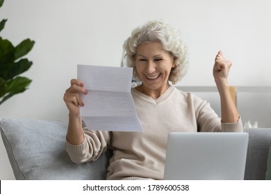 Smiling Elderly Woman Sitting On Couch In Living Room Reading Great News In Postal Paper Correspondence Letter From Bank Feels Overjoyed Very Happy By Free Of Financial Obligations, Paid Debt Concept