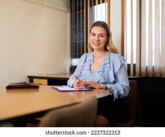 Smiling elegance business woman in office interior filling up documents - Shutterstock ID 2227322313