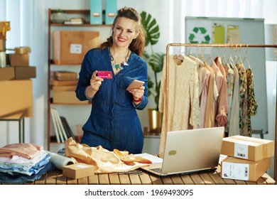 Smiling Elegant 40 Years Old Small Business Owner Woman With Smartphone And Credit Card In The Office.