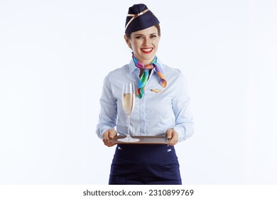 smiling elegant flight attendant woman against white background in uniform with a glass of champagne. - Shutterstock ID 2310899769