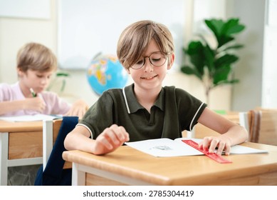 Smiling elementary school boy studying with notebook in bright classroom, happy childhood education and focused learning concept, Back to school