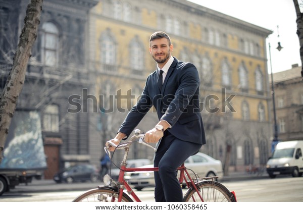 Smiling employee riding\
a bike to work\
