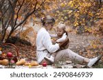 smiling enjoying mother and her young daughter sitting blanket autumn forest. picnic basket and food. autumn weekend park for two. motherhood. care and upbringing girl toddler 2 years old