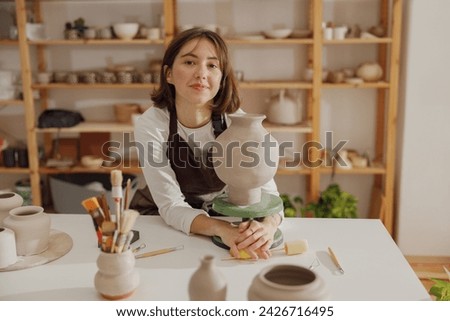 Similar – Woman in work wear in her workshop by table with handmade items