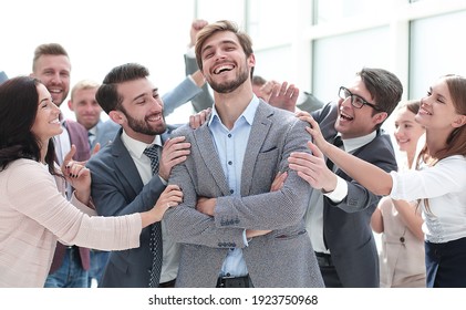 smiling entrepreneur on the background of jubilant business team - Shutterstock ID 1923750968