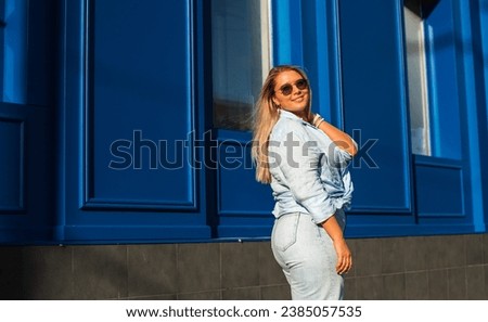 Smiling European plus size model in casual clothes, city behind her. Pretty nice chubby woman