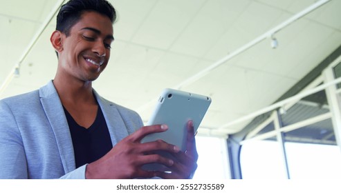 Smiling executive using digital tablet in office