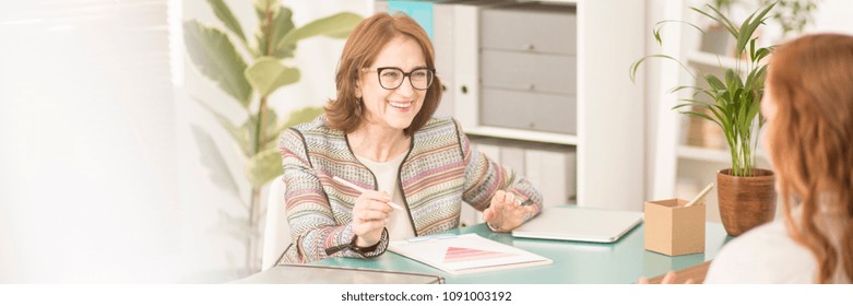 Smiling, Experienced Advisor Talking To Her Female Patient During Therapy