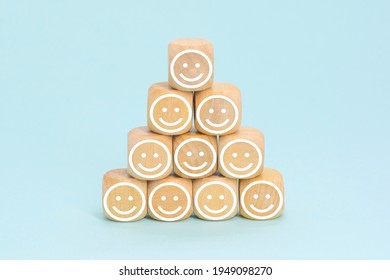 Smiling face icons on wooden cubes. Business service rating, customer satisfaction or teamwork concept.