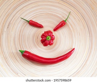 Smiling Face Spicy Red Chili Peppers On Wooden Plate