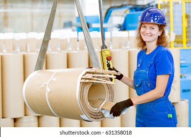 Smiling factory woman worker moving high voltage transformer coil with workshop overhead crane - Powered by Shutterstock