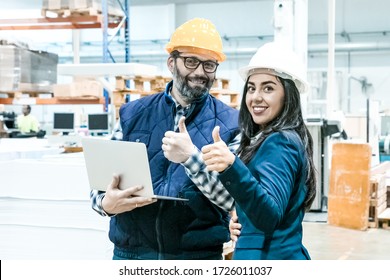 Smiling Factory Workers Showing Thumbs Up. Front View Of Cheerful Employees Posing With Laptop At Manufacturing Plant. Print Manufacturing Concept