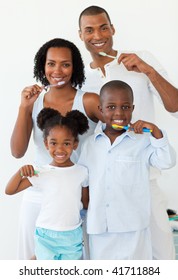 Smiling Family Brushing Their Teeth In The Bathroom