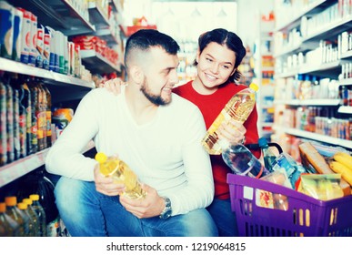 Smiling Family Couple Buying Vegetable Oil At Supermarket
 