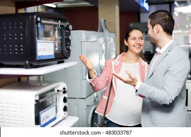 Smiling family couple choosing new microwave in supermarket. Focus on the woman - Shutterstock ID 483033787