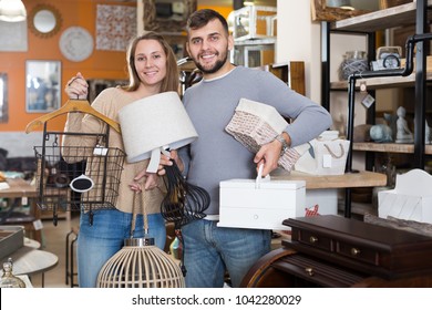 Smiling Family Demonstrating Their Buies In Shop Of Secondhand Furniture