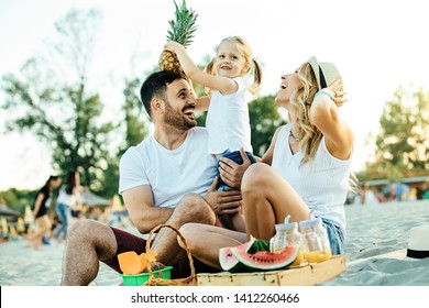 Smiling Family Enjoying Beach And Having Picnic.