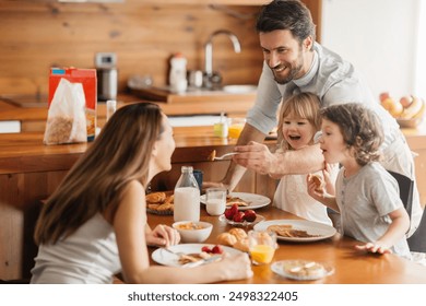 Smiling family enjoying breakfast together in cozy kitchen - Powered by Shutterstock