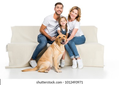 Smiling Family With Golden Retriever Dog Sitting On Sofa, Isolated On White