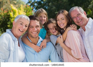 Smiling family and grandparents in the countryside embracing and smiling at camera