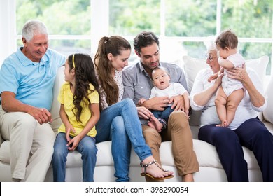 Smiling family with grandparents sitting on sofa at home