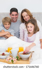 Smiling Family Having Breakfast In Bed