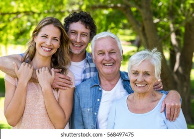 Smiling Family Hugging In A Park