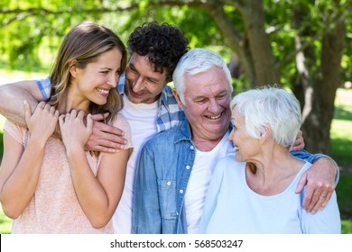 Smiling Family Hugging In A Park