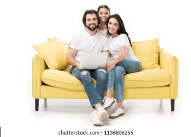 Smiling Family With Laptop Sitting On Yellow Sofa Isolated On White