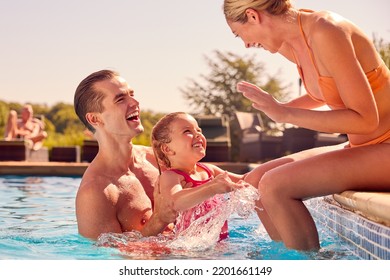 Smiling Family On Summer Holiday Playing In Swimming Pool - Powered by Shutterstock