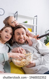 Smiling Family With Popcorn Watching Movie At Home