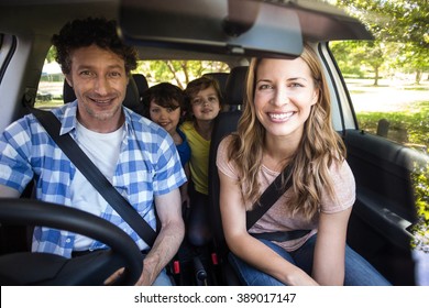 Smiling Family Sitting In The Car And Driving