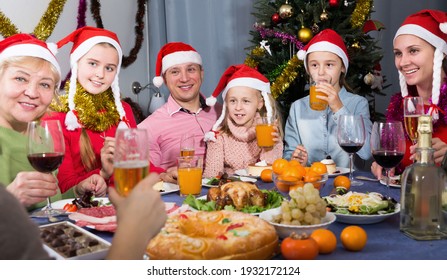 Smiling Family Is Talking At The Table In Time Celebration New Year At Home..