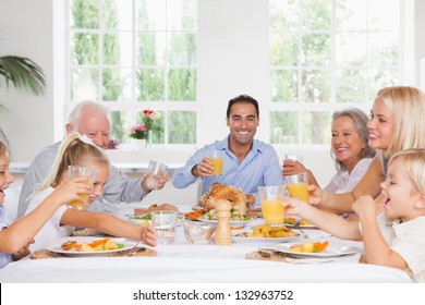 Smiling Family Toasting At Thanksgiving At The Dinner Table