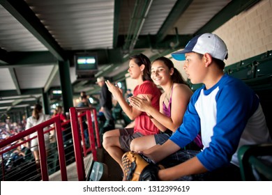 Smiling Family Watching A Baseball Game.