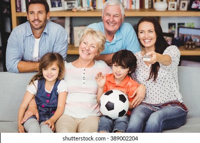 Smiling Family Watching Football Match At Home