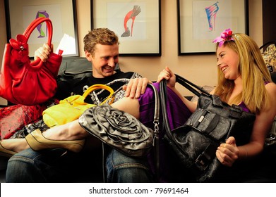 Smiling Fashionable Rich Attractive Couple Sitting On Sofa At Home Laying Under Lots Of Handbags