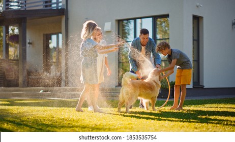 Smiling Father, Daughter, Son Play With Loyal Golden Retriever Dog, Spraying Each other with Garden Water Hose. On a Sunny Day Family Having Fun Time Together Outdoors in Backyard. - Powered by Shutterstock