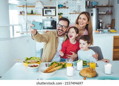 Smiling father holding cellphone, making selfie shot, recording video with happy wife and little kids siblings. Excited parents looking at mobile screen with kids, feeling excited. - Powered by Shutterstock